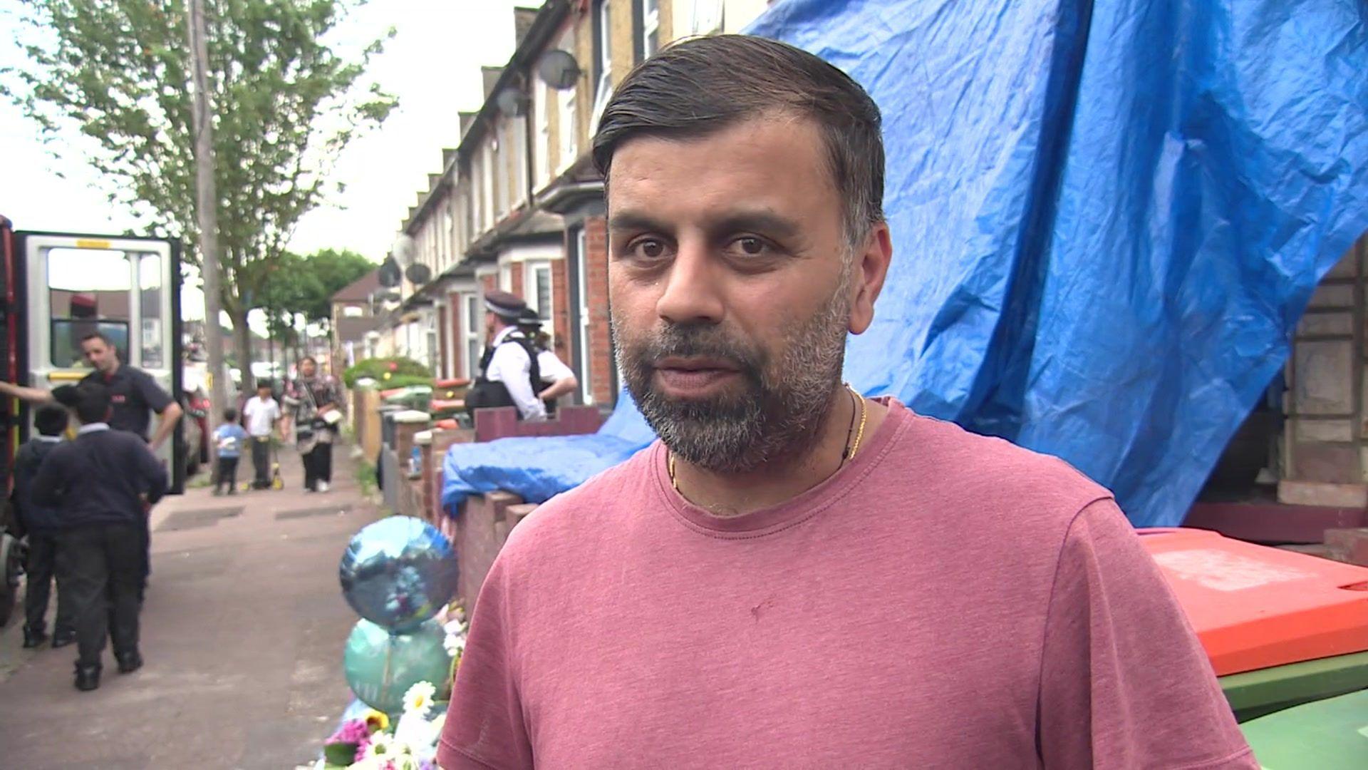 Cheerag, a man in a light red t-shirt, stood next to balloons and floral tributes