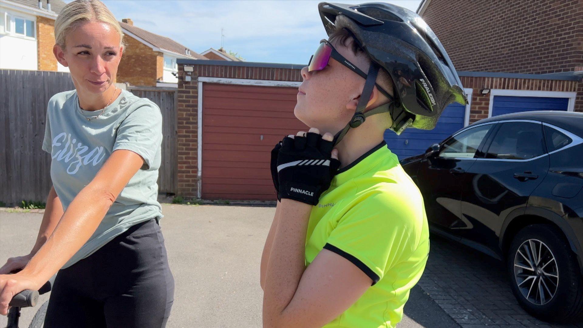 Dexter puts on his cycle helmet watched by his Mum Sam.