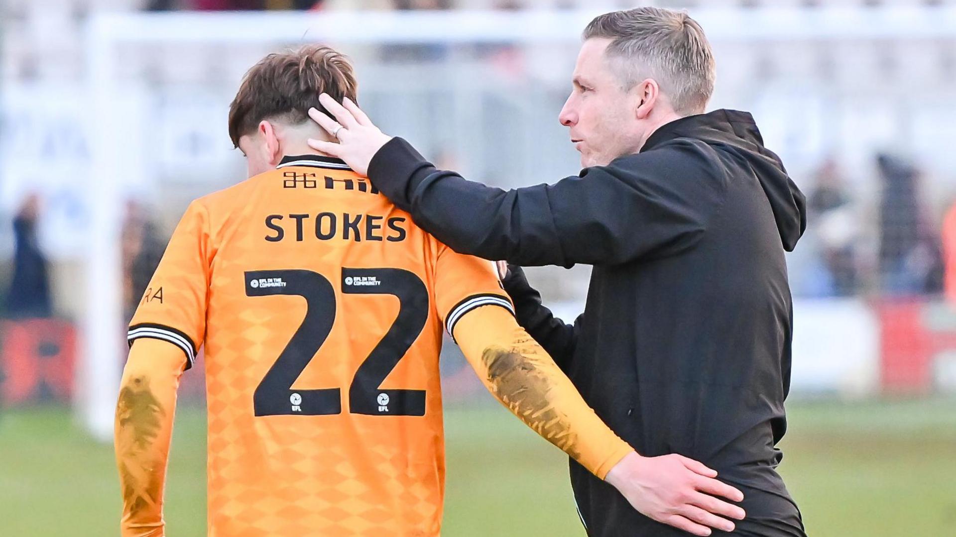 Cambridge boss Neil Harris gives Josh Stokes a congratulatory pat following their win over Stockport