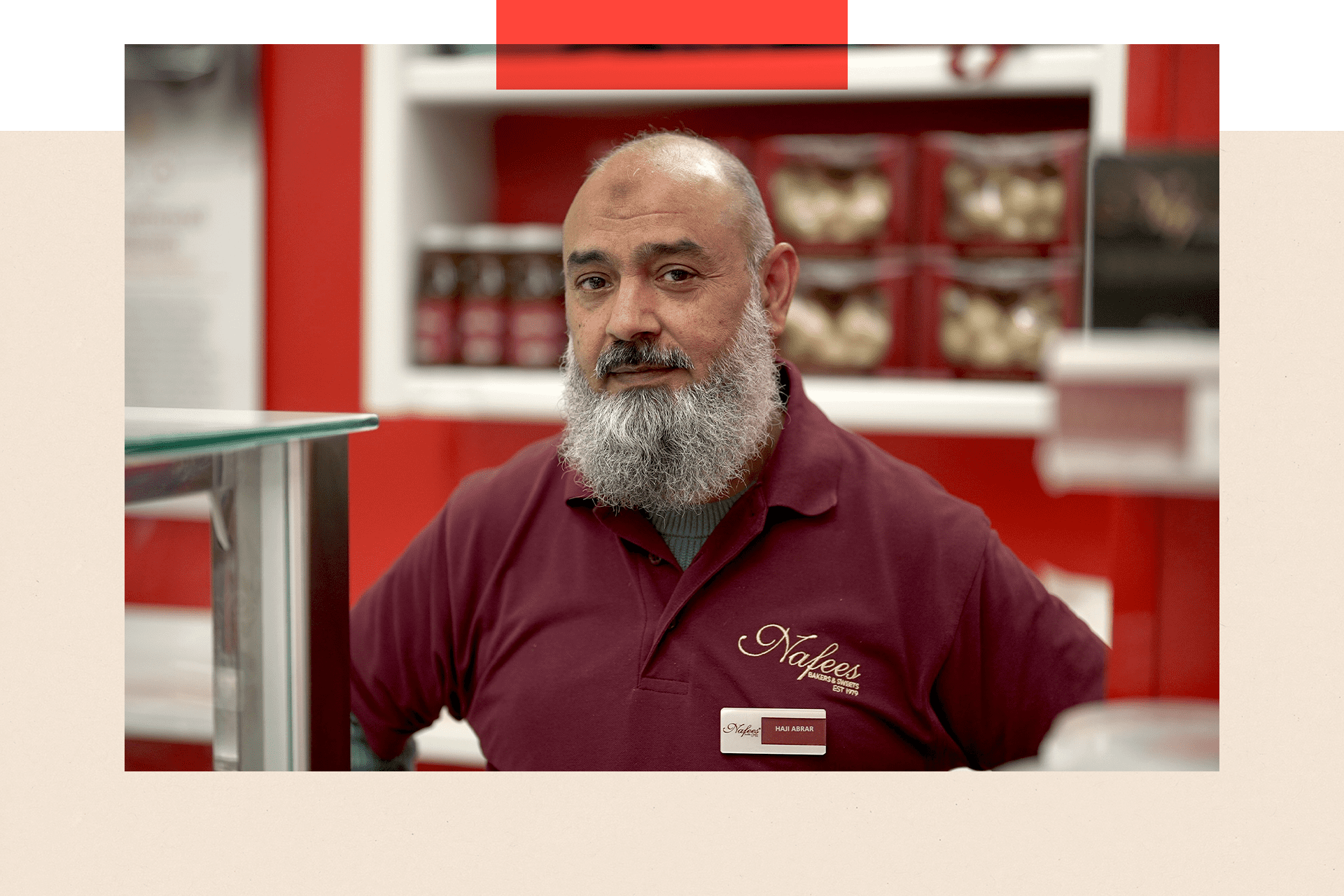 Haji, a man with a beard and a t-shirt, stands in a shop