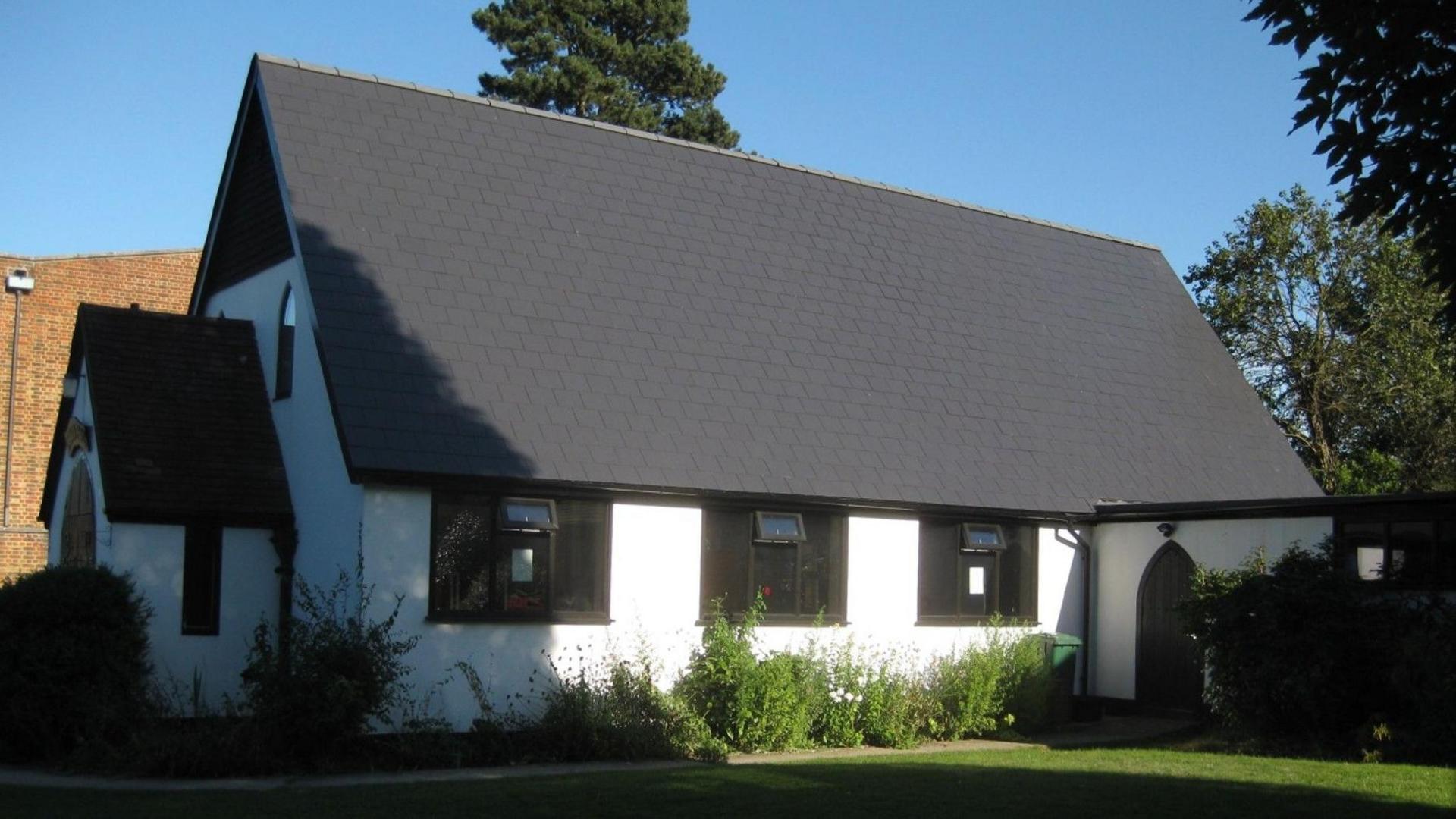 A white and black church building shrouded in shadow.