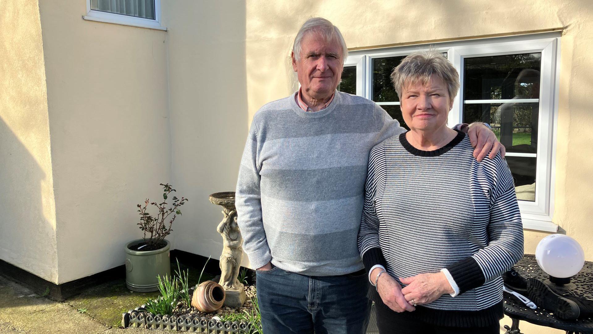 Simon and Sally Hearse standing outside their home