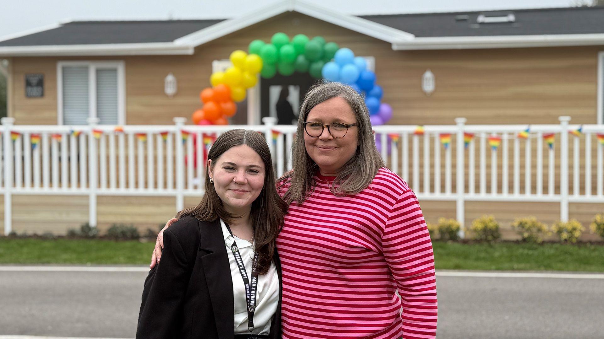 Hannah Roberts standing next to her mother Gail Iredale outside their new respite lodge at Mercia Marina in Willington