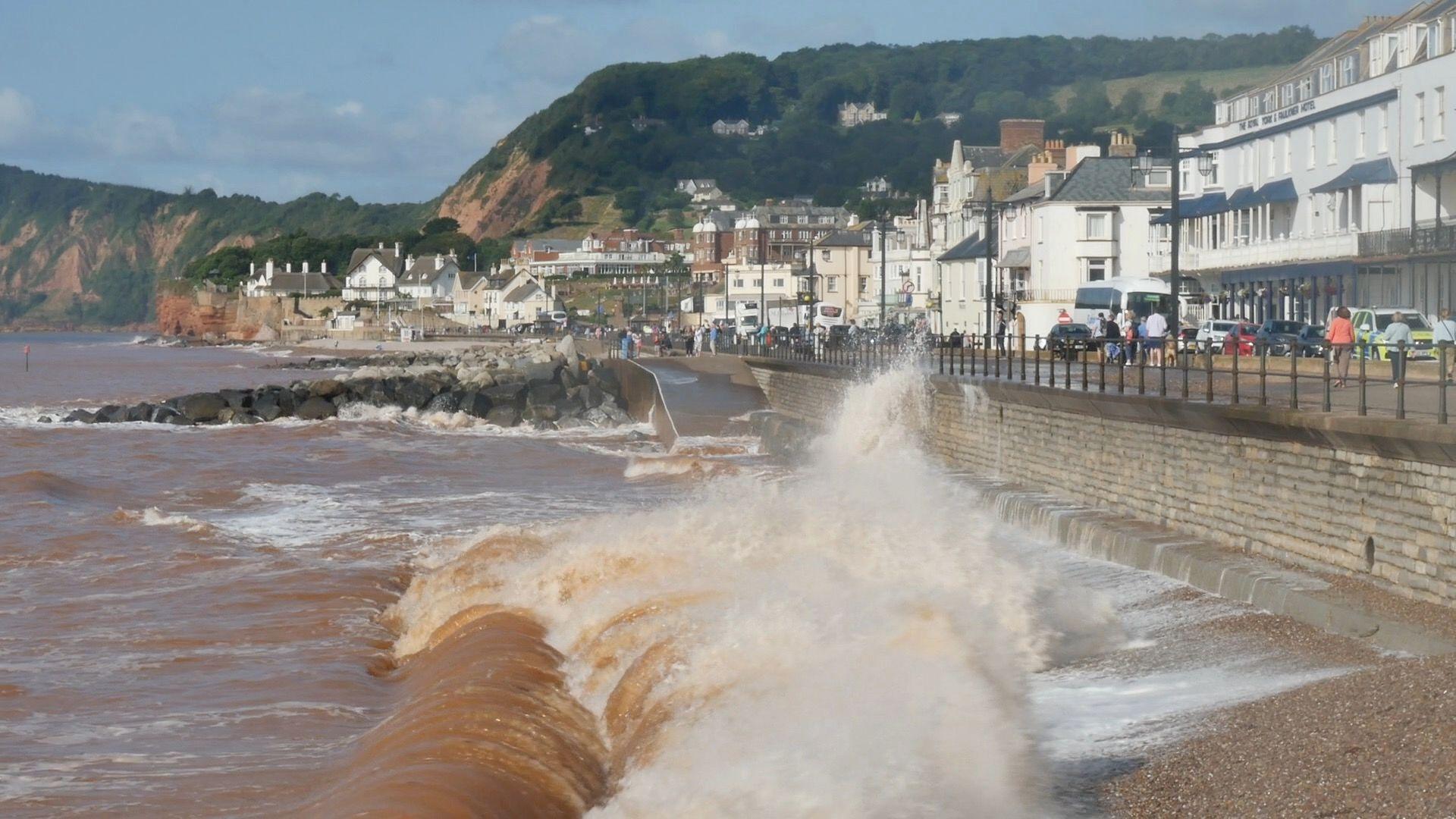 Waves breaking and splashing onto the esplanade in the coastal town of Sidmouth 