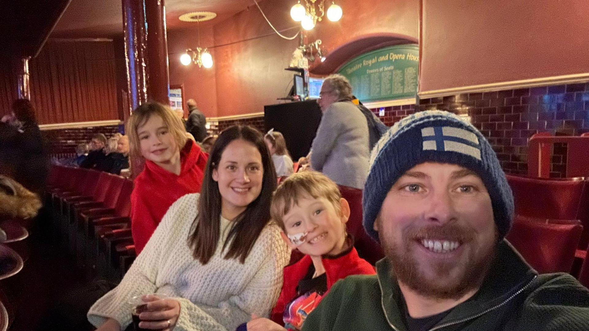 Oliver with mum Laura, dad, James, and brother Alfie, seven, at a theatre 