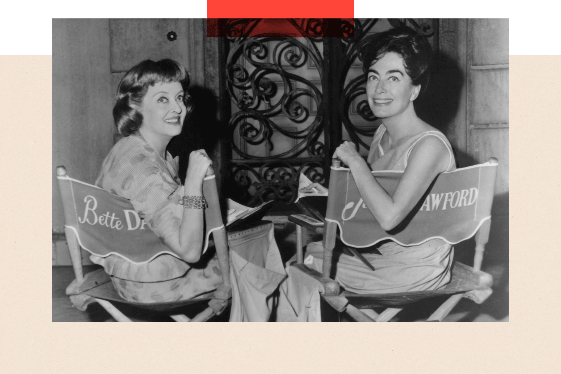 Black and white photo of Bette Davis and Joan Crawford, sitting in director's chairs with their names embroidered on the backs