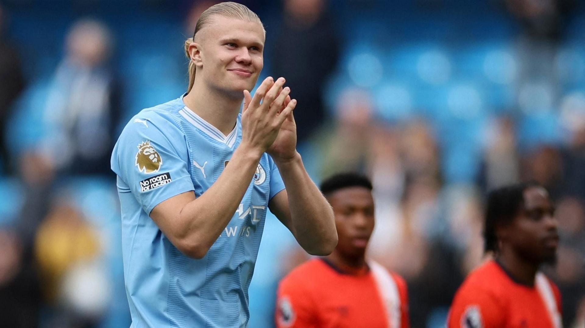 Haaland clapping with Luton players in the background