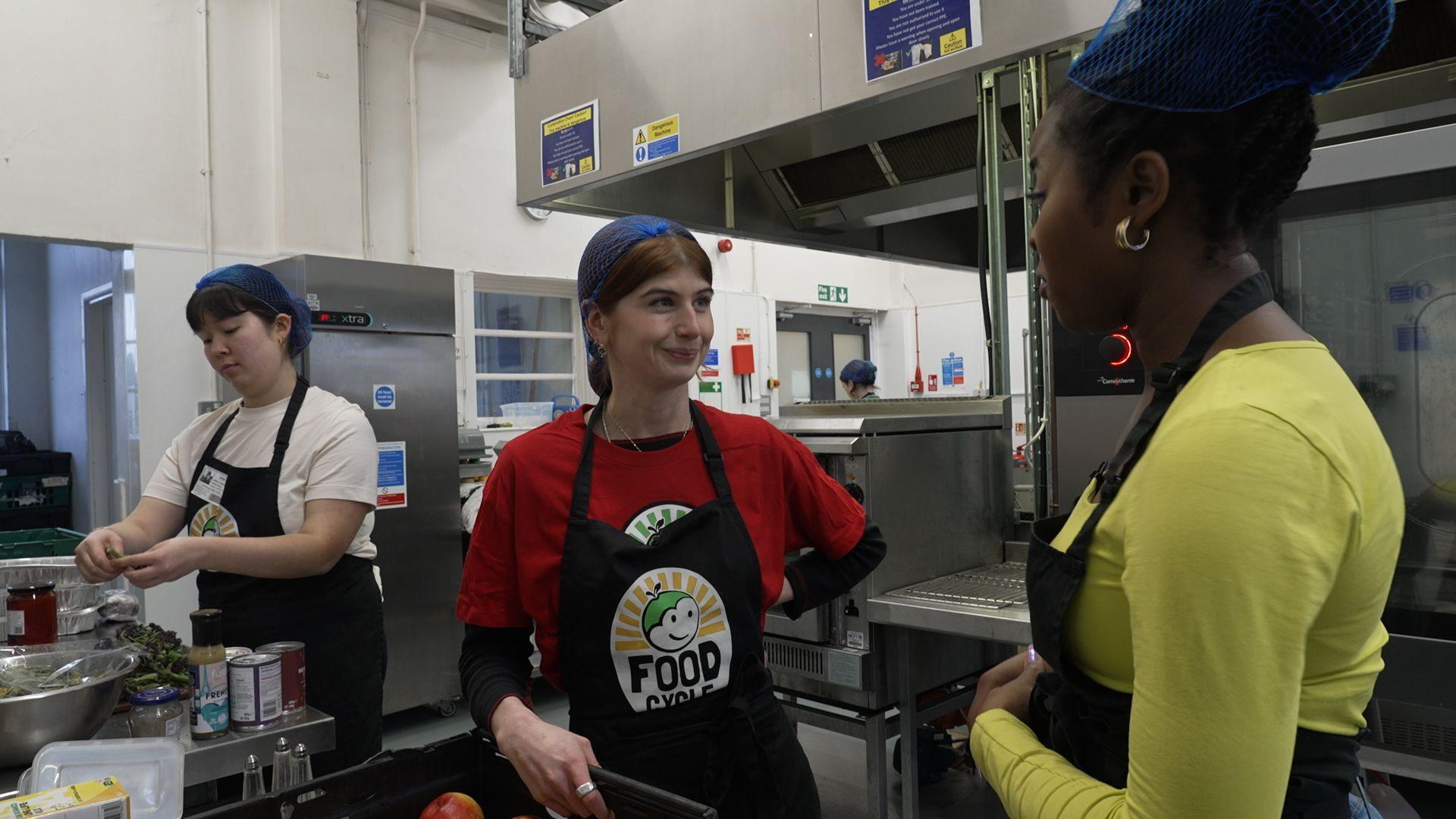 Two people stood talking in a kitchen