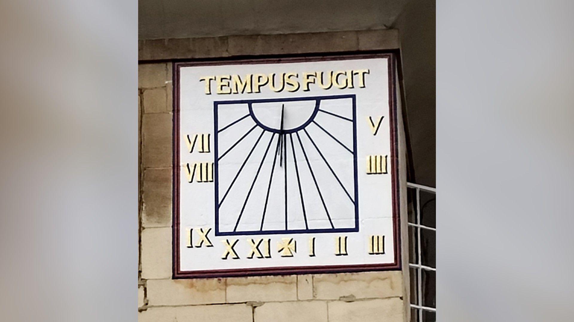 A sundial with the Latin words "Tempus Fugit" at the top.