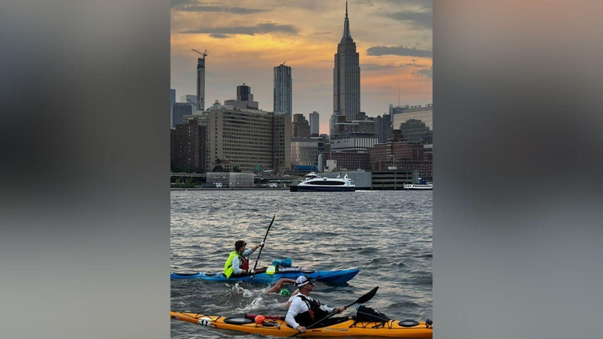 Swimmer in the foreground with manhattan skyline in background skyline