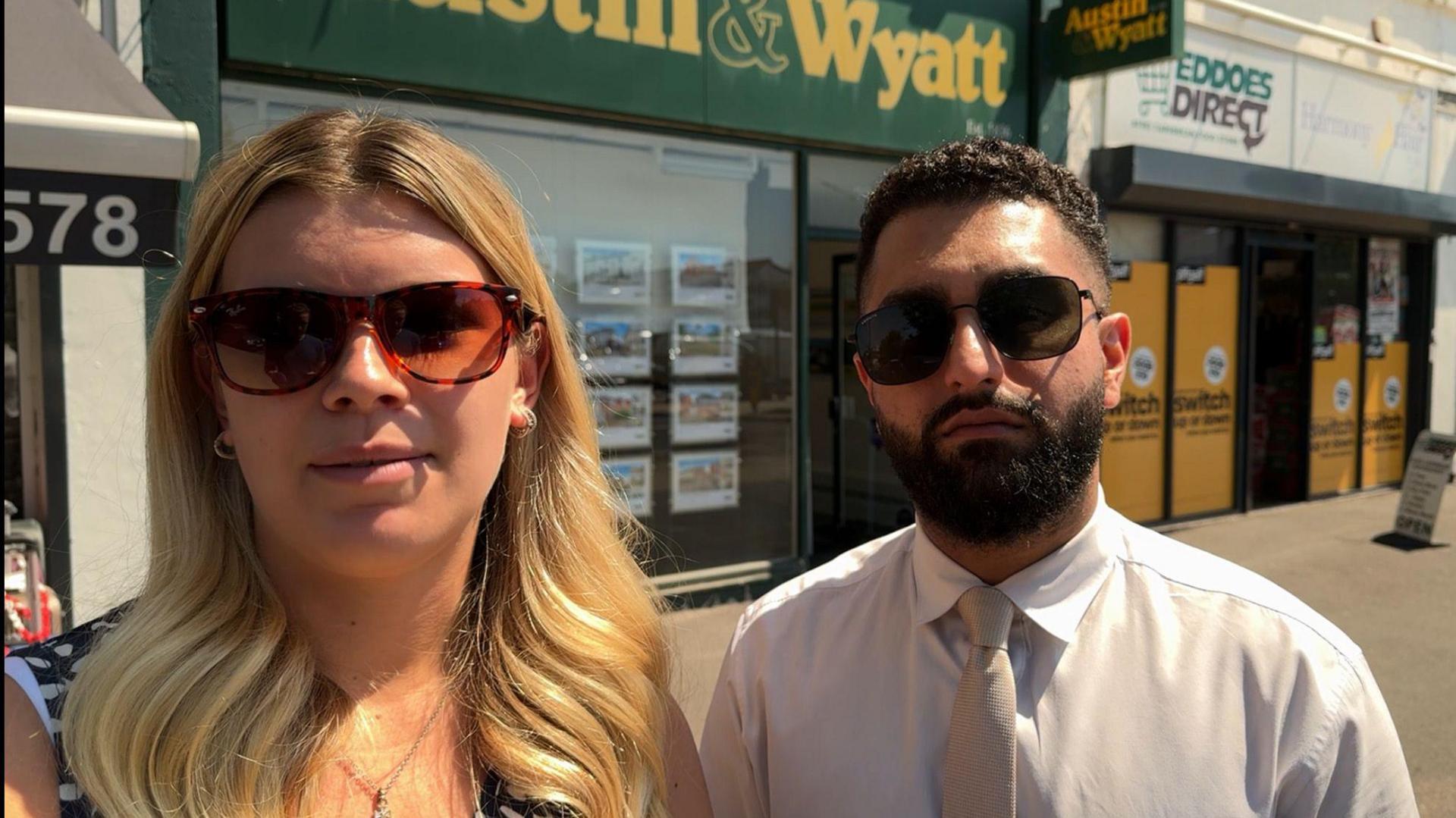 Emily Davis and AJ Singh standing outside estate agents office