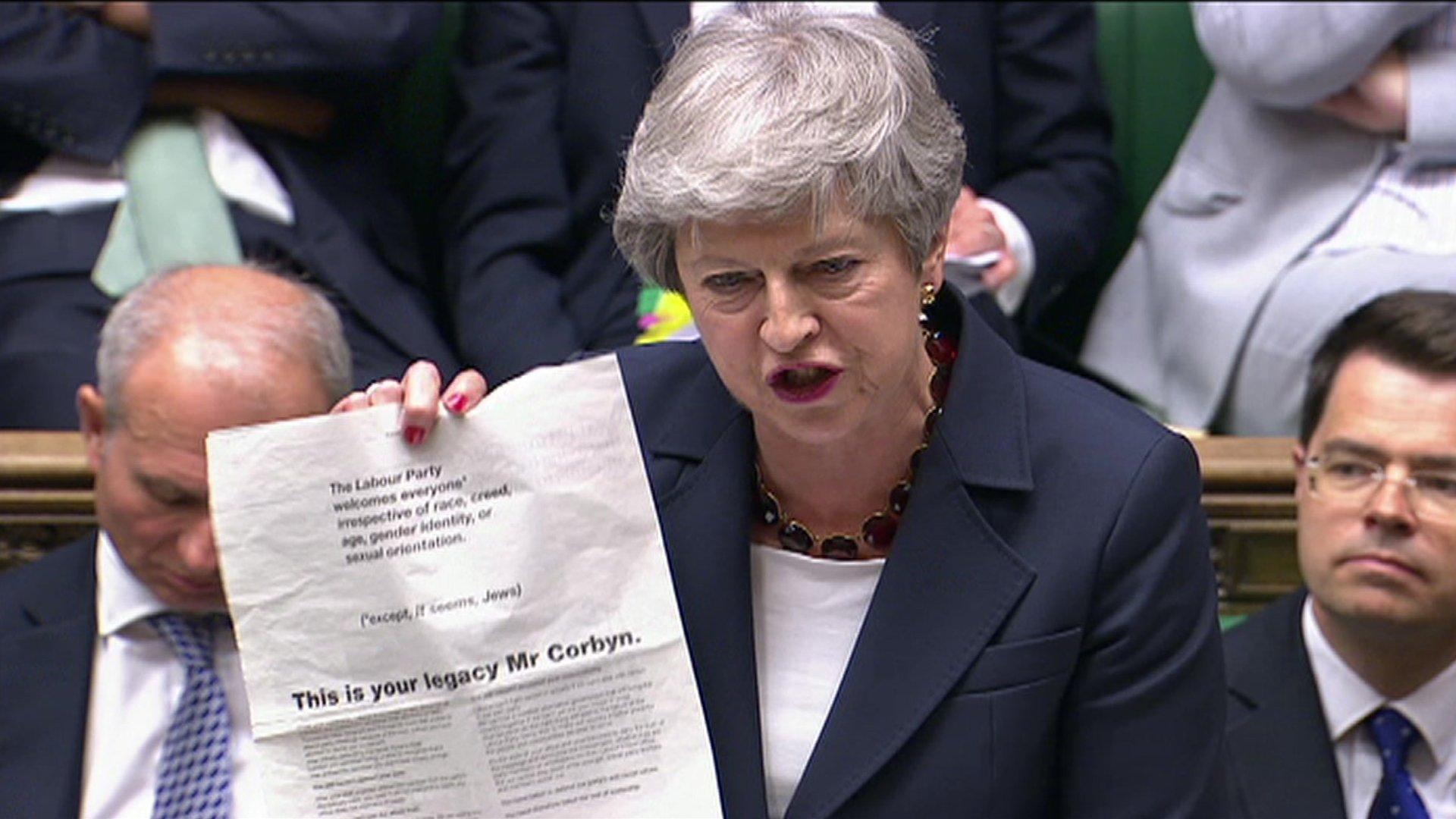 Theresa May brandishing copy of Guardian advert in the Commons