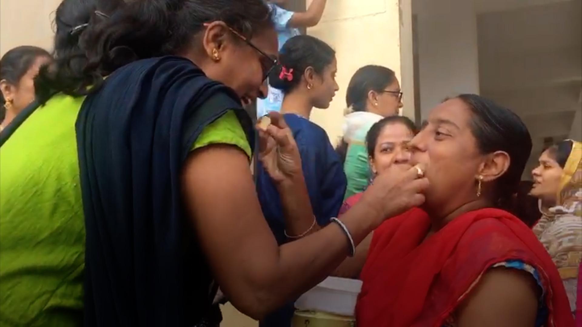 Women feeding sweets to each other