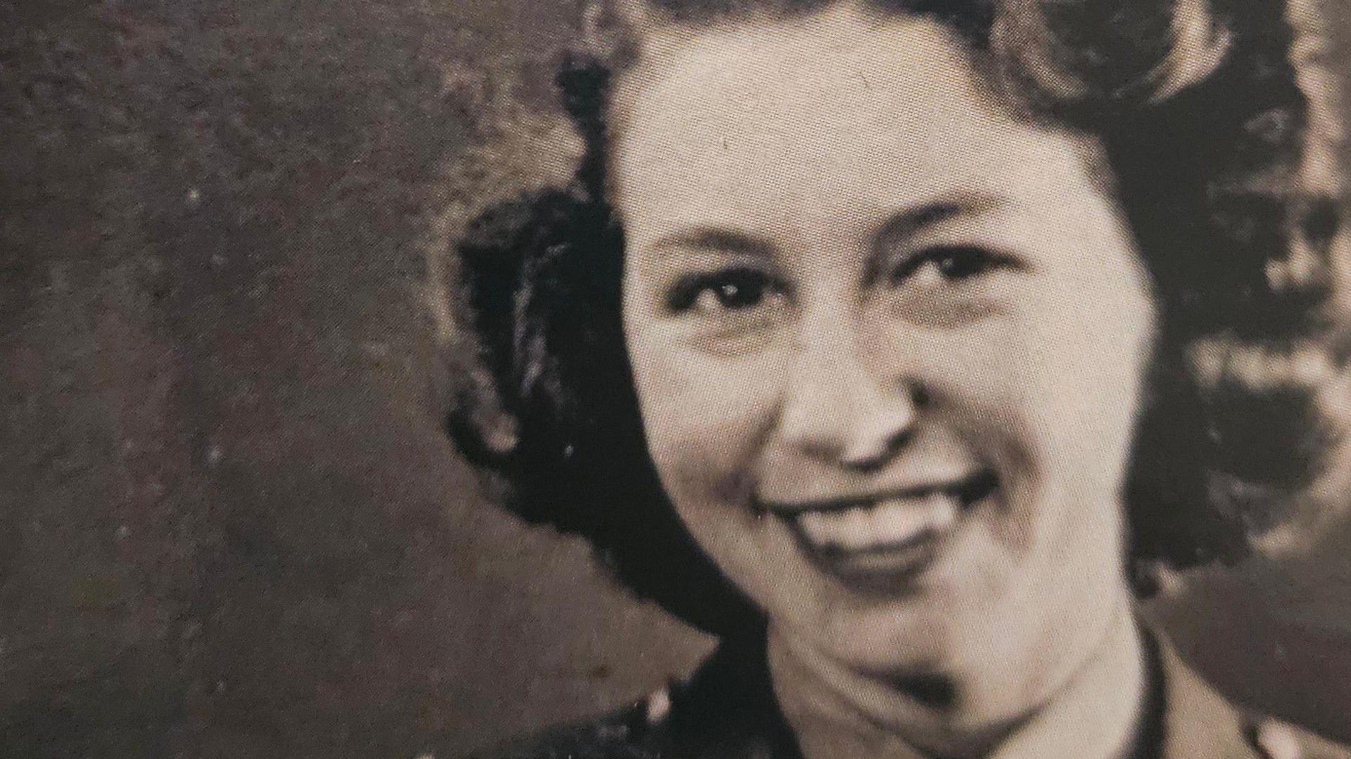 Head and shoulders image of a smiling 20 year old woman with curled hair taken in 1943
