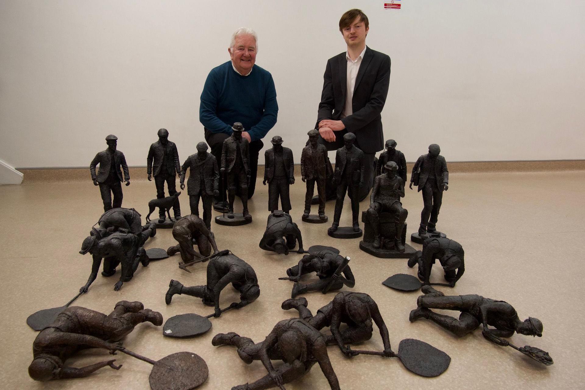 Gallery manager John Thompson and Michael Hanwell with the collection of about 20 miniature miners on the floor.