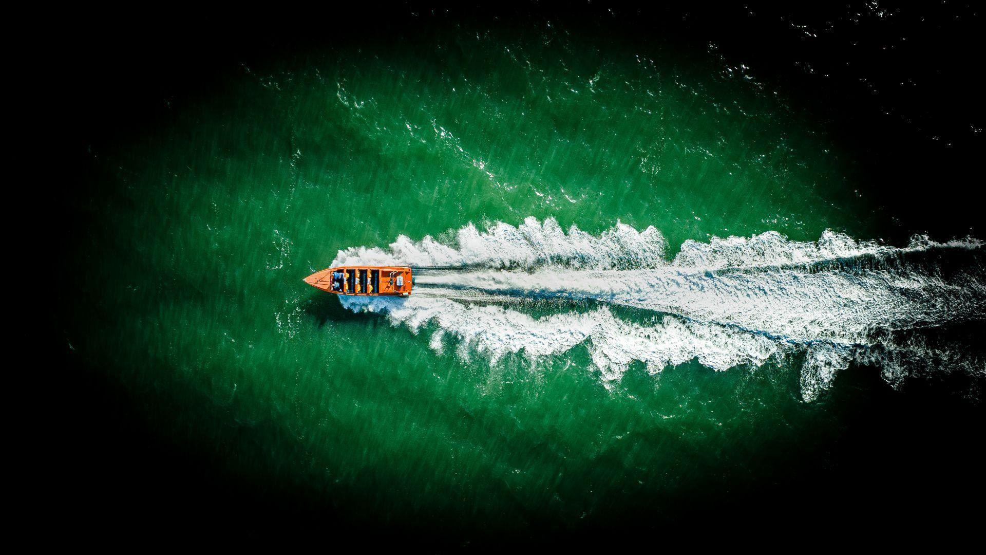 Cwch cyflym yn gwibio drwy'r môr ger Llandudno