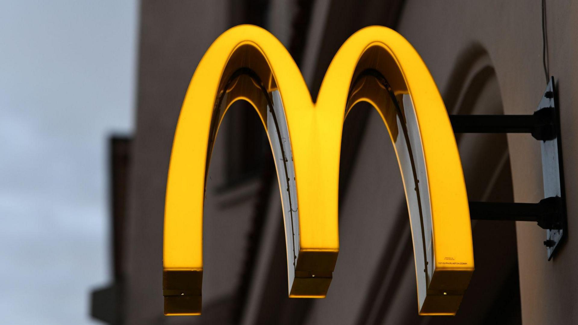 A close-up of the golden M of a McDonald's sign