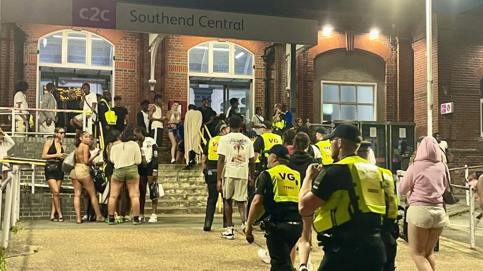 Police officers amid a crowd at Southend Central railway station