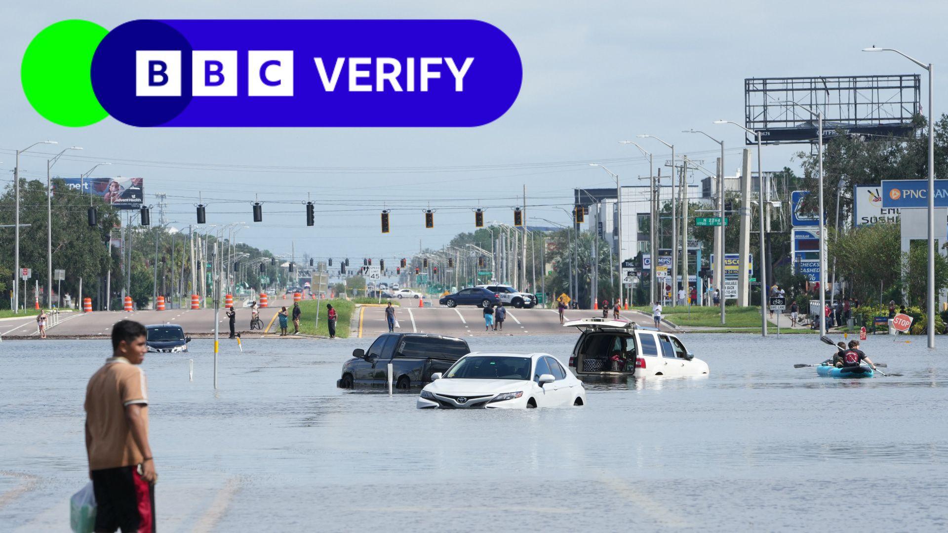 A young man walks past vehicles flooded in the water in the streets of the Southeast Seminole Heights section of Tampa.