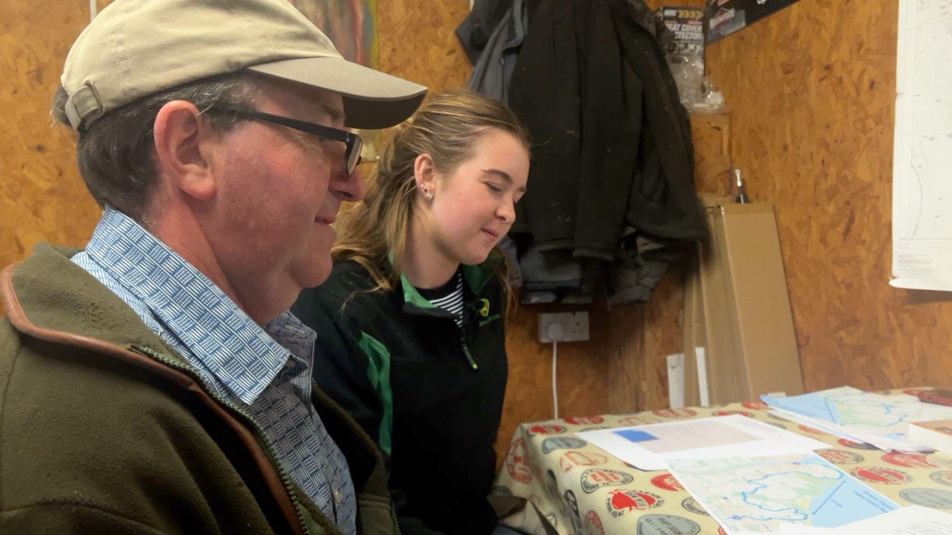 Mark and Fleur Orlik in the left hand of the frame looking down at a map of the proposed route on a table. 