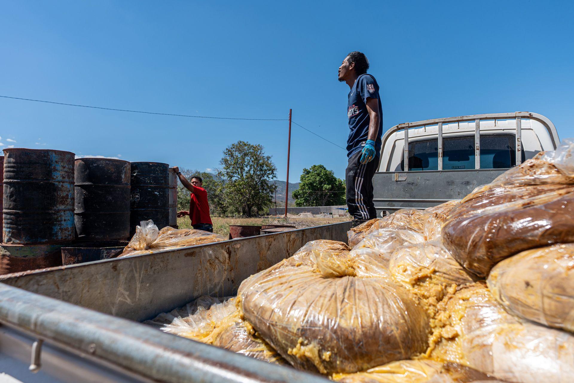 Workers store a shipment of raw beef tallow obtained from a slaughterhouse