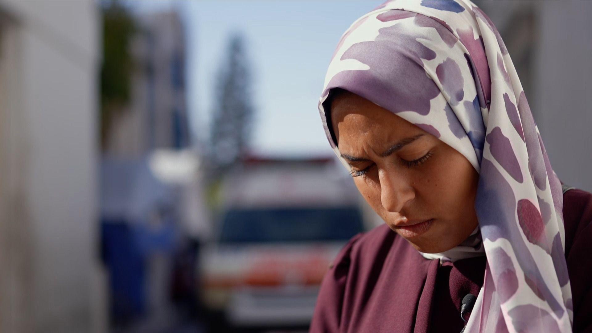 Nevine Al Dawawi wears a lilac and white headscarf and a maroon top. 