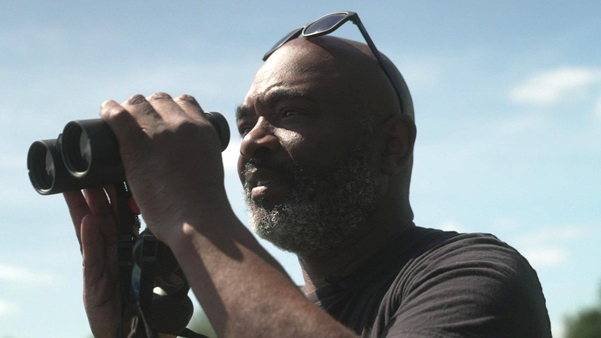 urban birder looking through binoculars