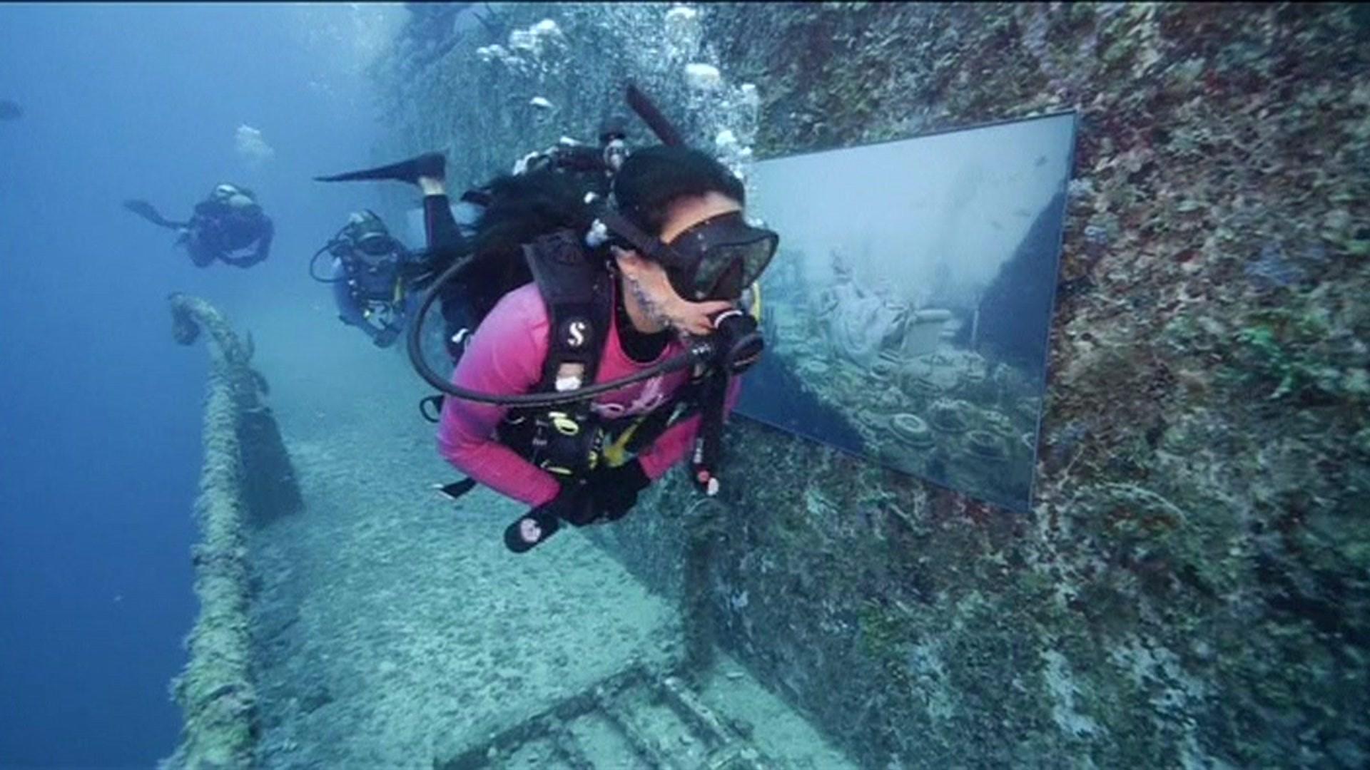 Divers check out an art exhibition