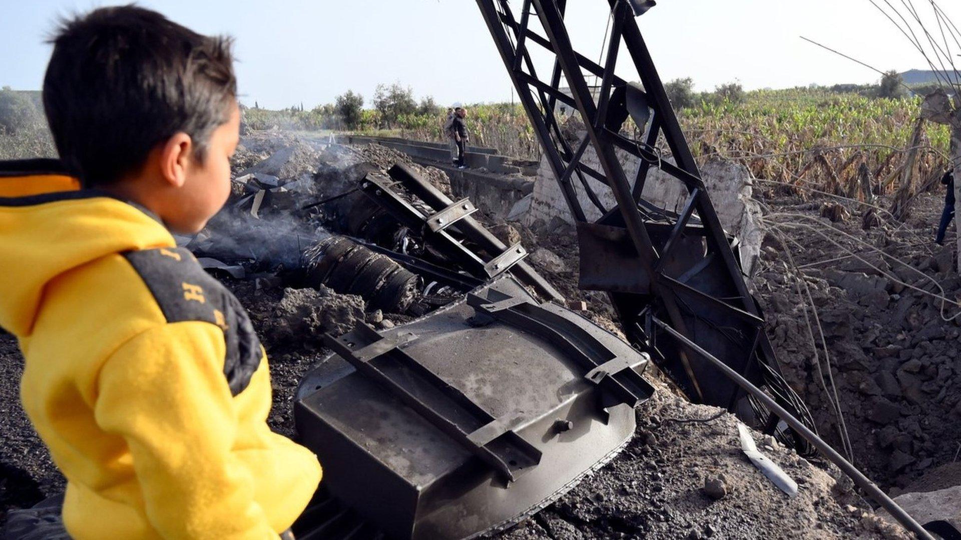 A child looks at a small bridge near the southern Lebanese village of al-Qulaila that was destroyed in an Israeli air strike (7 April 2023)