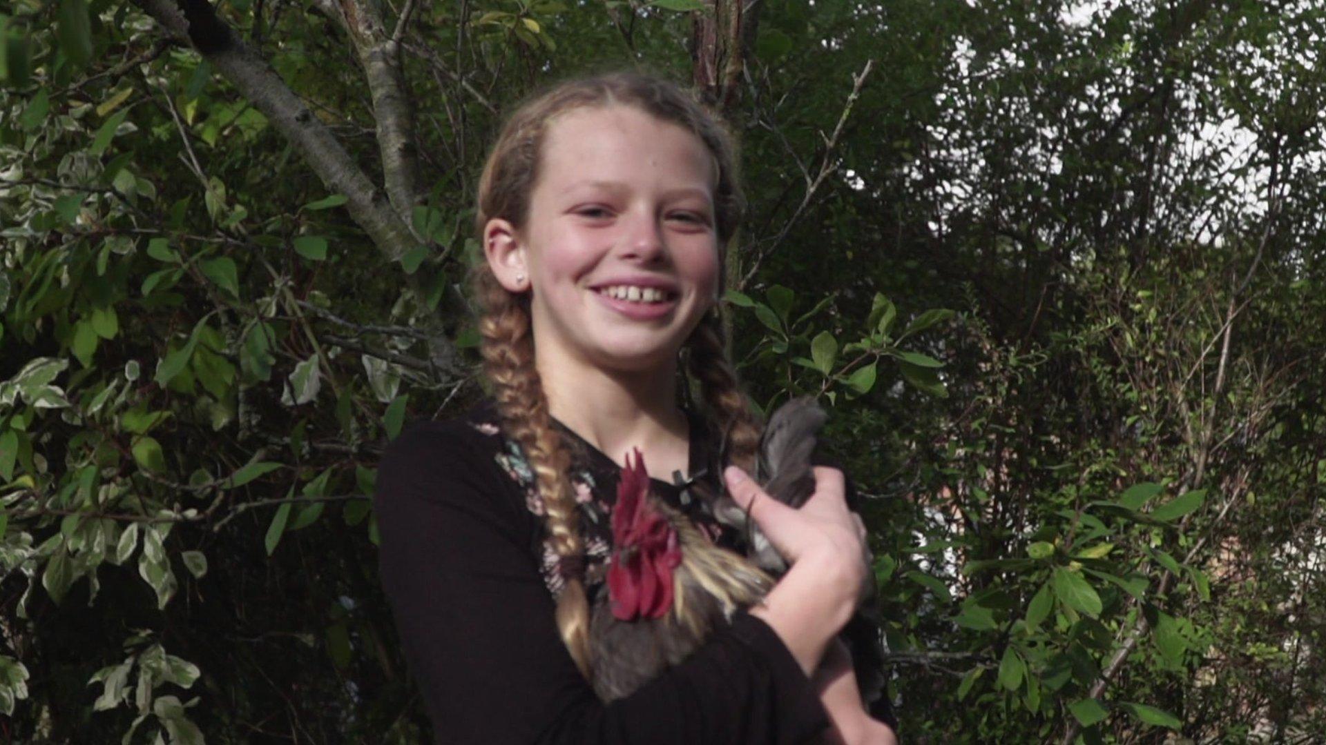 A girl holding a chicken