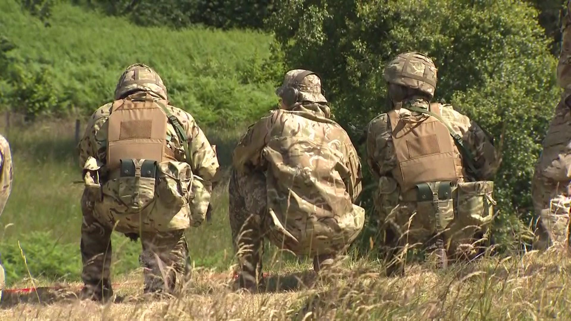 Three Ukrainian soldiers with their backs turned at an MOD base in the UK