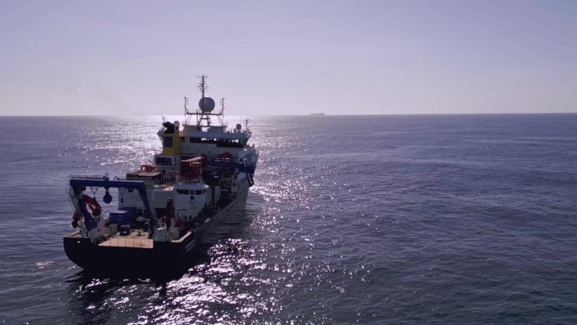 Royal Research Ship Discovery in the Atlantic heading towards the sun and the horizon.