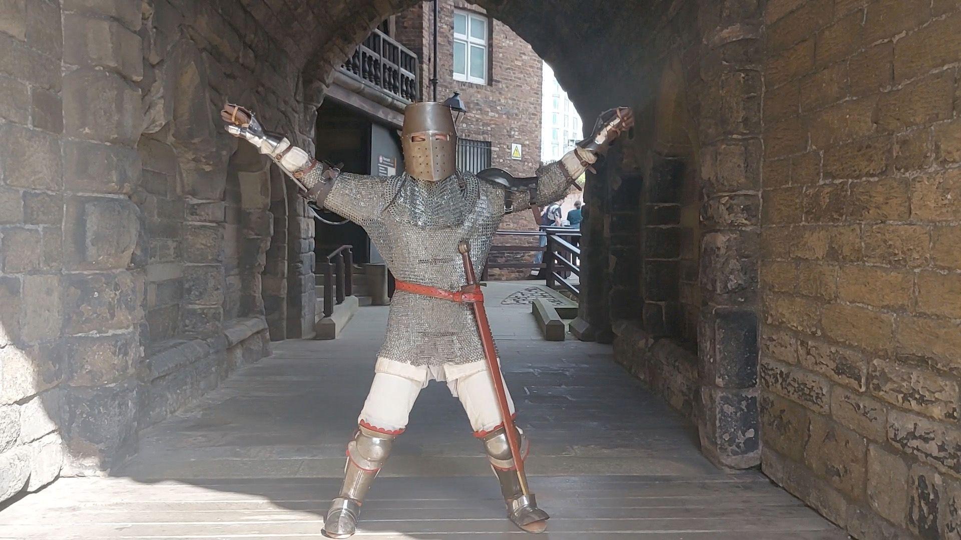 James Lovatt, aka Sir Runs a Lot, dressed in medieval chainmail and full helm, doing star jumps