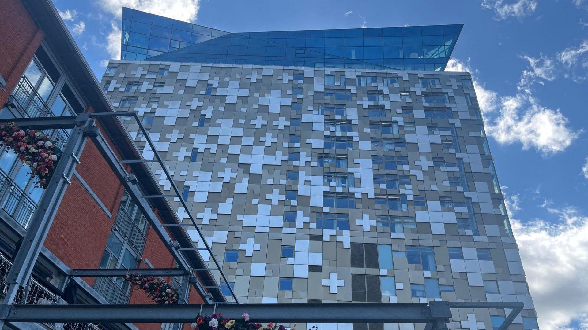 Looking up to the glass fronted restaurant on the top of the building