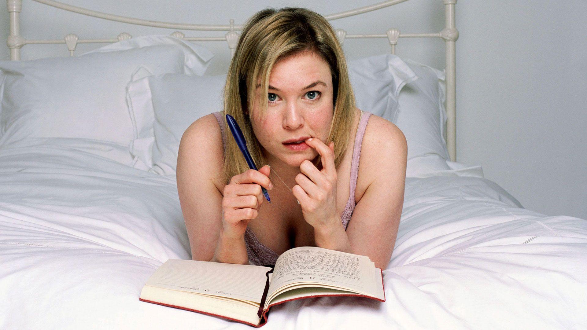 Bridget Jones - Renee Zellwegger in character, lying on a bed writing her diary.