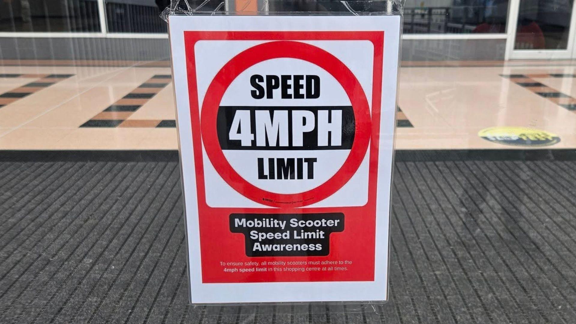 A sign in the window of Idlewells Shopping Centre which shows 4mph, and says "mobility scooter speed limit awareness"