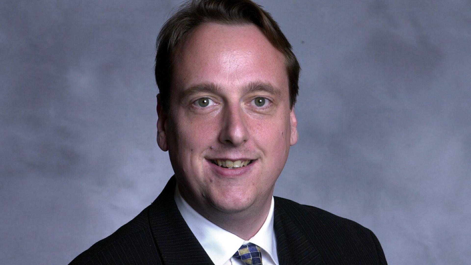 The leader of the Liberal Democrats at Wiltshire Council, Ian Thorn, poses for a picture in black suit, white shirt while wearing a colourful tie