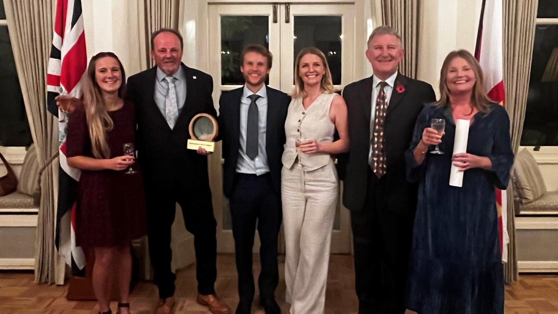 The six-person Barnes family. They are all dressed up smartly and smiling into the camera after being given their award.