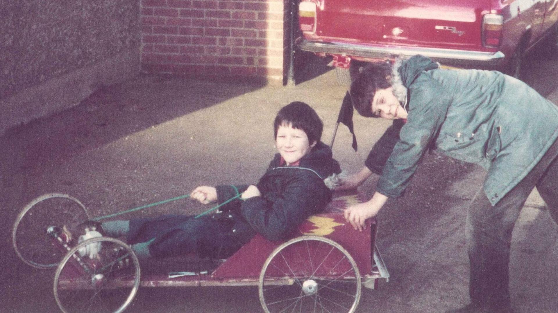 Mr Tanner as a child sat in the first go-kart he built, which was red with flames painted on the side