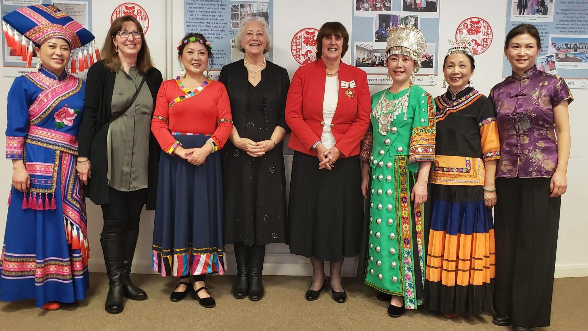 Organisers standing together in a photo. Some of the women are wearing traditional Chinese attire. They are all smiling at the camera 