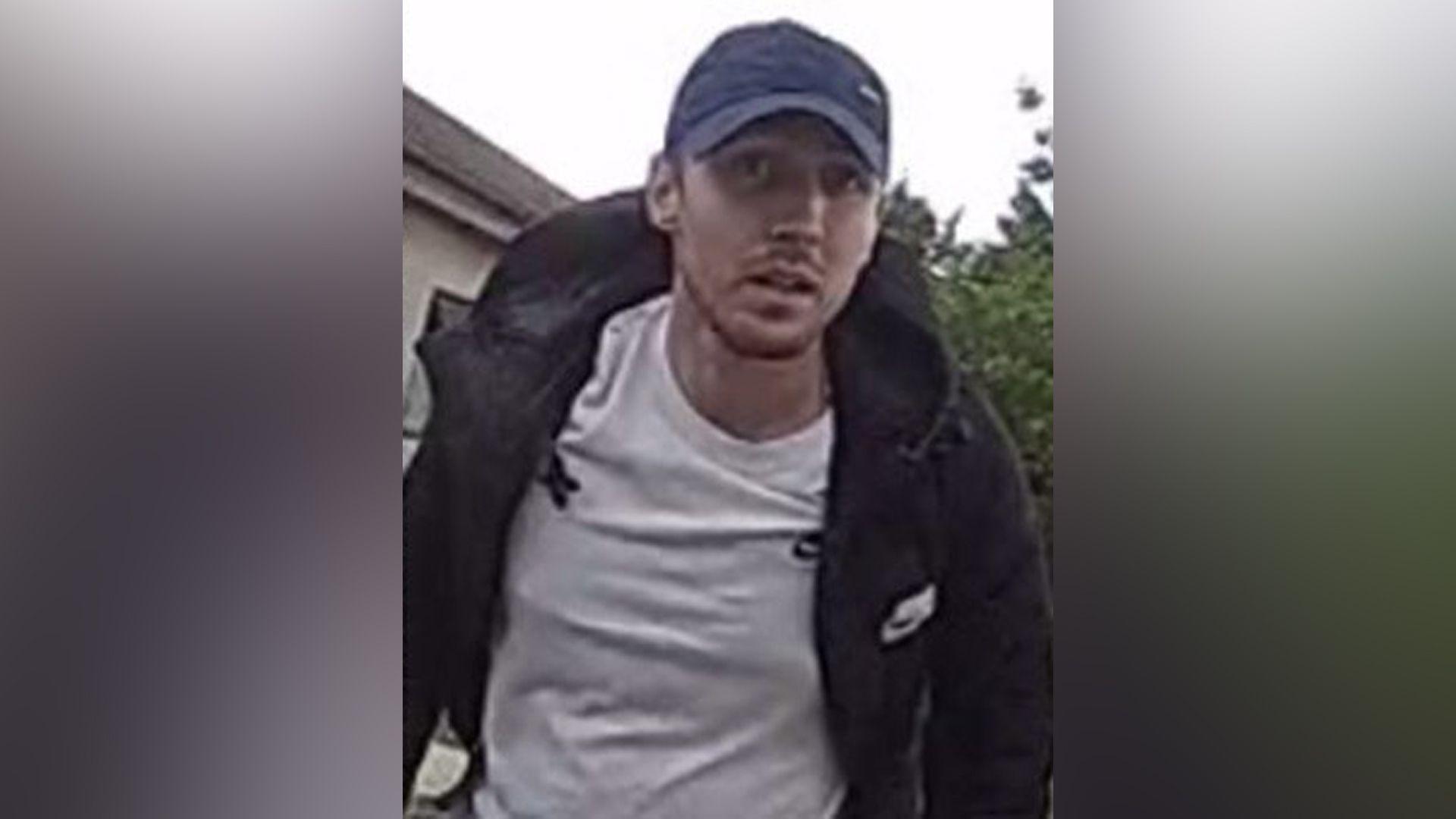 Kieron Nickels is wearing a dark jacket, a white t-shirt and dark cap.