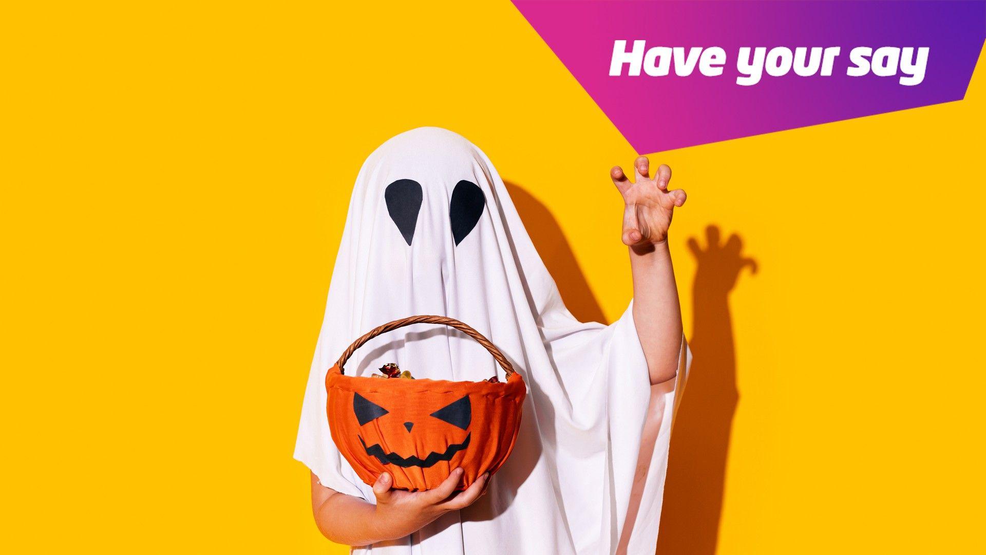 child dressed as ghost holding a pumpkin basket. 