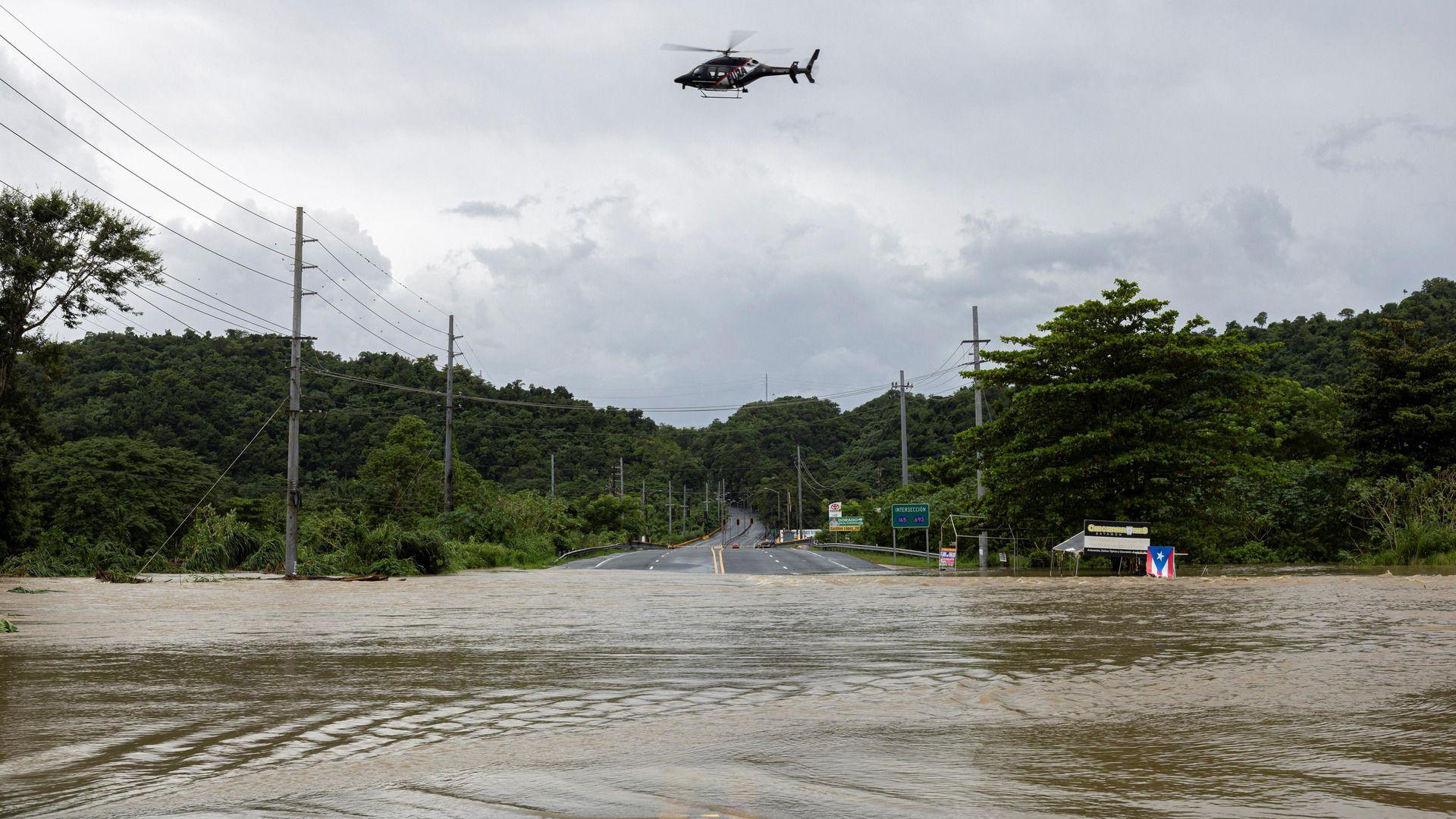 Police helicopter flies over a flooded area in the aftermath of Tropical Storm Ernesto in Toa Baja, Puerto Rico