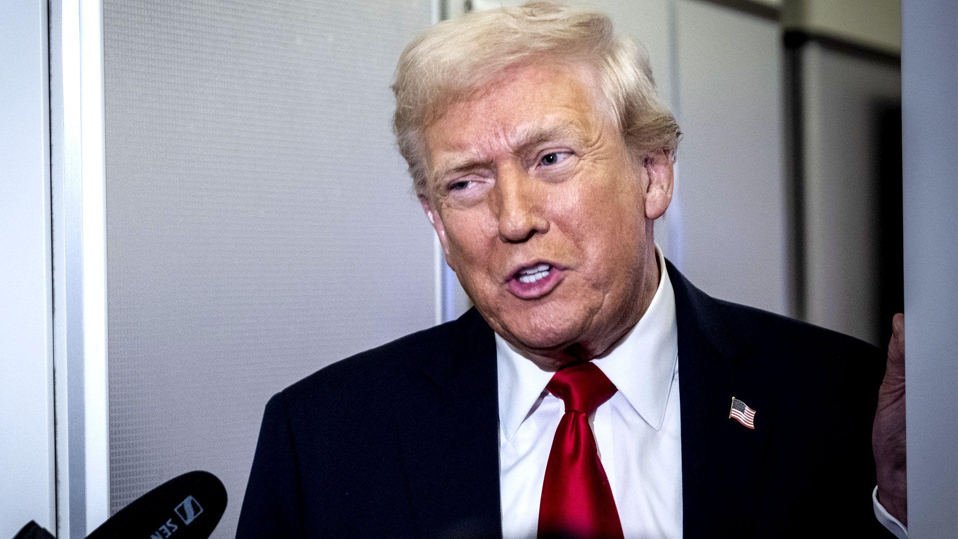 US President Donald Trump speaks to reporters on board Air Force One