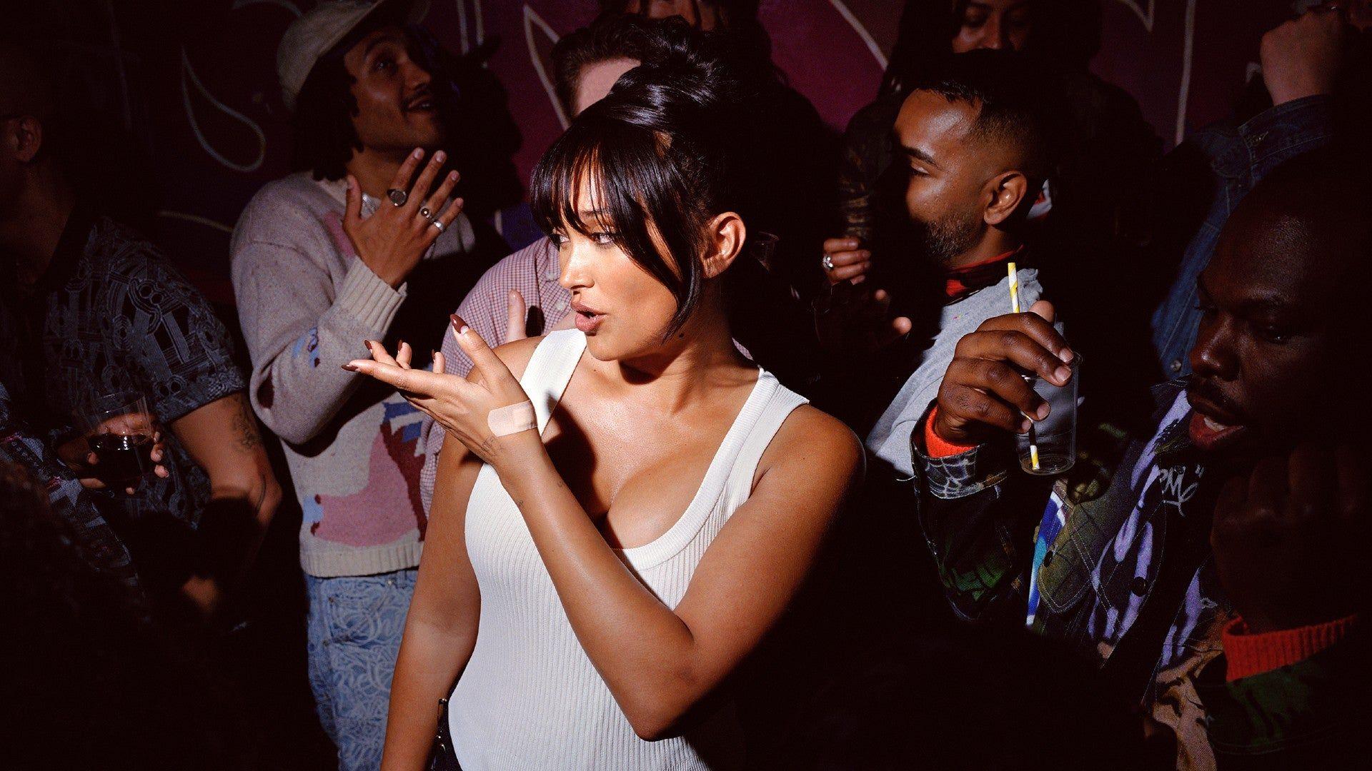 A spotlight picks Joy Crookes out of a crowd in a nightclub, in a promo shot for her new album
