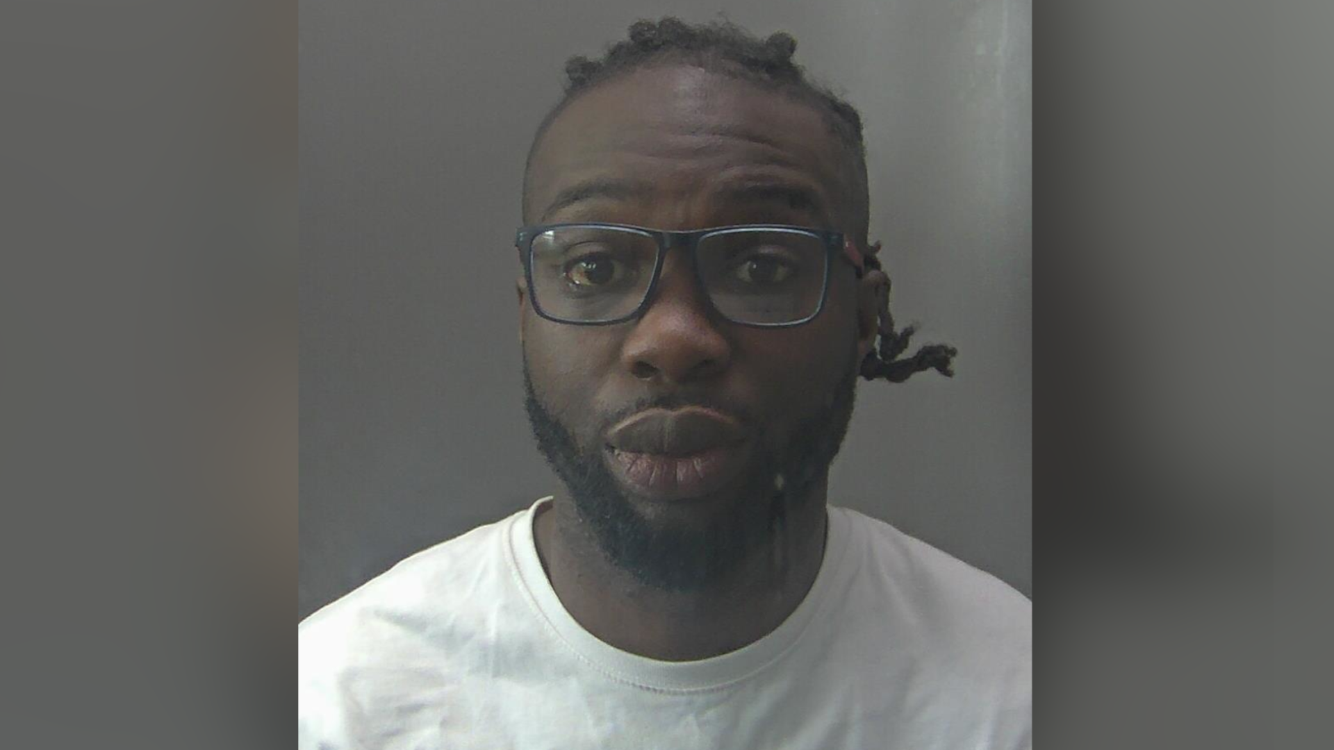 Ulili Ramalao, a man who is looking directly at the camera. He is wearing a white T-shirt and a pair of glasses on his face.