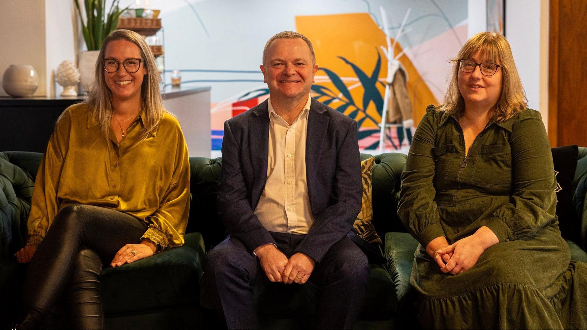 Three people, a man and two women, smile at the camera as they sit on the sofa. They are all representatives of Bristol Business Improvement Districts, known as BIDS. The man is in the centre of the picture