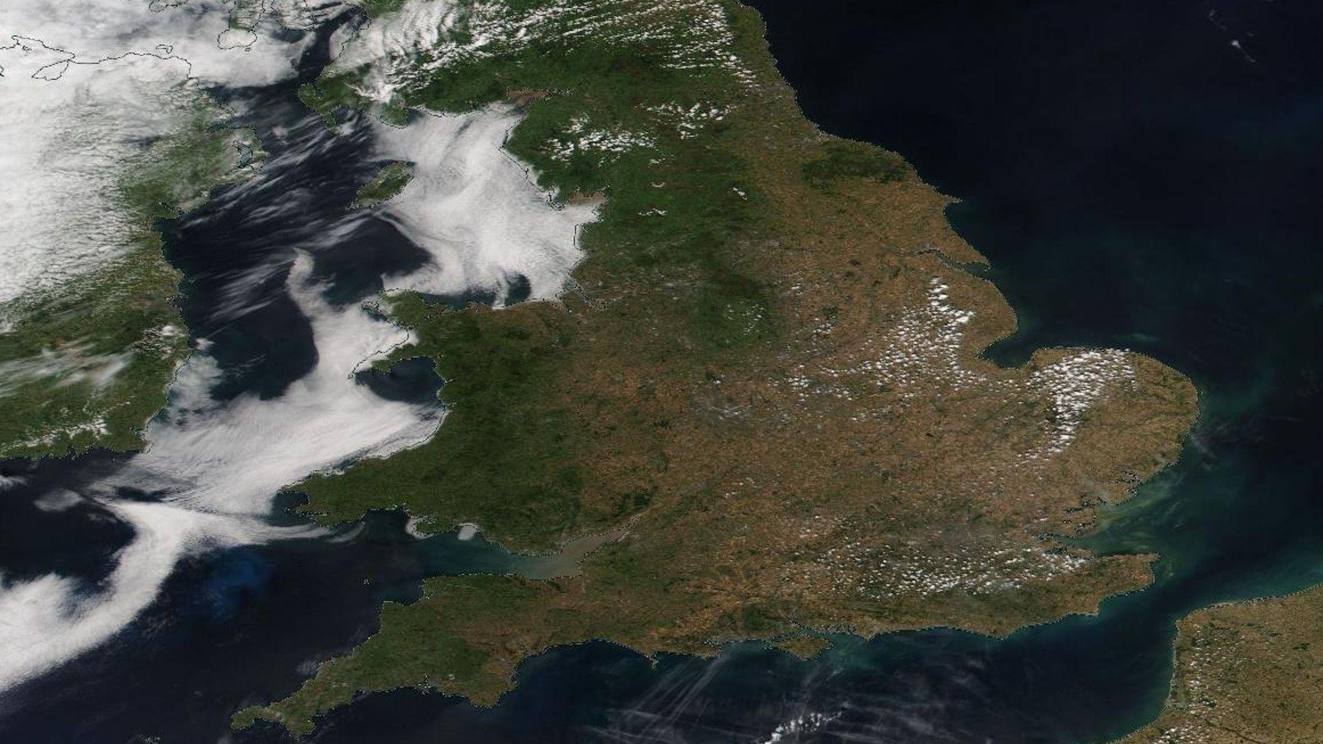 A NASA satellite image of England and Wales. Much of Wales and north-west England is a green colour, but the rest of England appears various shades of brown