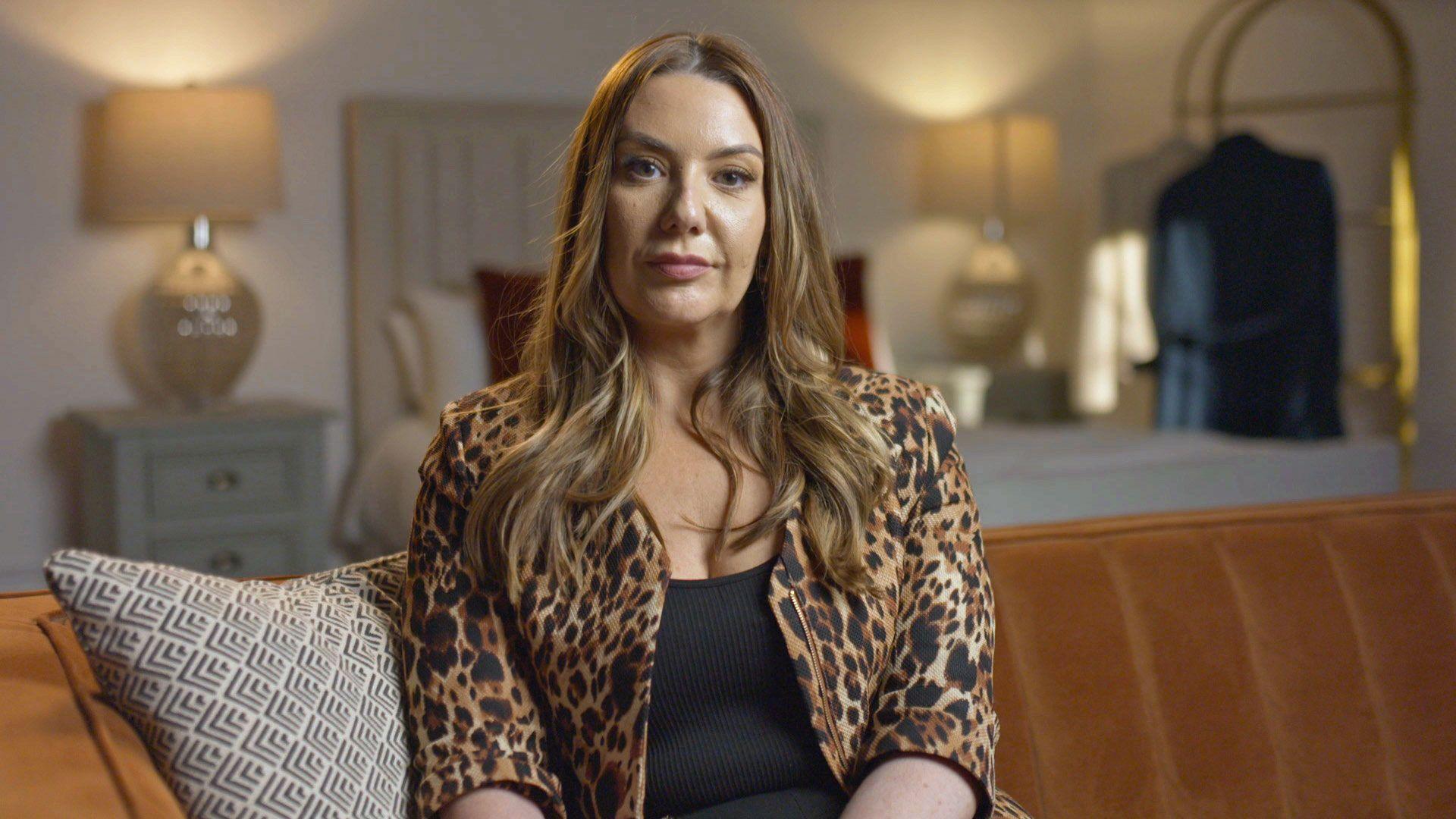 Photo of Lisa - not her real name - taken from the TV programme. She sits in a living room on a brown sofa lookinbg at the camera. She has long brown hair and is wearing a leopard print jacket and a black top.