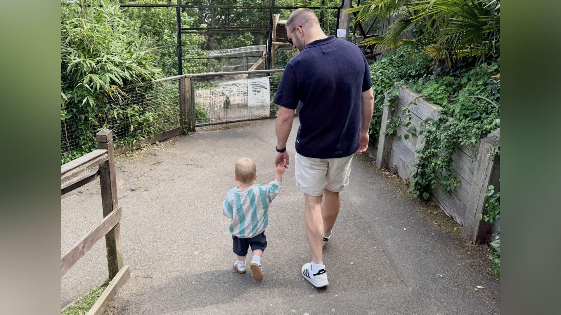 Steffan yn cerdded gyda'i blentyn bach yn gafael llaw